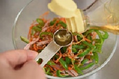 Cho ớt, thịt nguội vào tô lớn, cà rốt vắt ráo nước muối cũng cho vào chung rồi trộn đều lên. Sau đó, rắc mè rang, 2 muỗng cà phê dầu mè, 1 muỗng cà phê cà phê giấm và trộn đều một lần nữa là xong rồi đó.