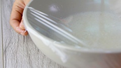 Chuẩn bị phần xôi: gạo nếp sau khi ngâm nở thì chắc ráo nước, thêm vào 100ml nước cốt dừa và 1 muỗng canh dầu ăn, trộn đều. Sau đó dùng màn bọc thực phẩm bọc tô gạo nếp lại, cho vào lò vi sóng quay 10 phút ở 650 watz. Sau khi quay lúc này gạo nếp đã nở thành xôi, bạn dùng đũa trộn đều xôi lên cho tơi và không còn dính vào đáy tô.