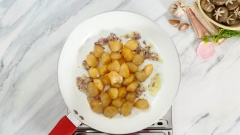 Bắc chảo nóng, thêm vào 2 muỗng canh dầu ăn, cho 10gr hành tím băm và 10gr tỏi băm vào phi thơm. Sau đó thêm cồi sò điệp đã ướp vào xào sơ 2 phút cho cồi sò săn lại thì trút ra dĩa để riêng.