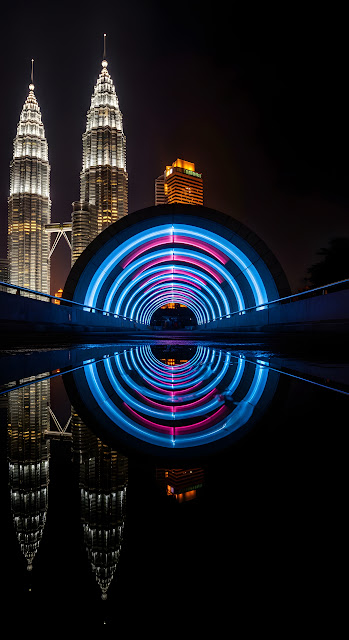 Dramatic Night Reflection of Petronas Towers and Light-Painted Blue Tunnel in Wet Foreground - Free mobile Wallpaper