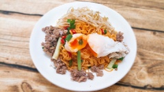 Xếp mì ra dĩa, cho bò băm, trứng lòng đào lên trên, cắt thêm vài lát ớt, dùng kèm tô nước dùng tuyệt ngon. Chỉ với vài bước đơn giản là bạn đã hoàn thành món mì trộn muối tôm rồi.