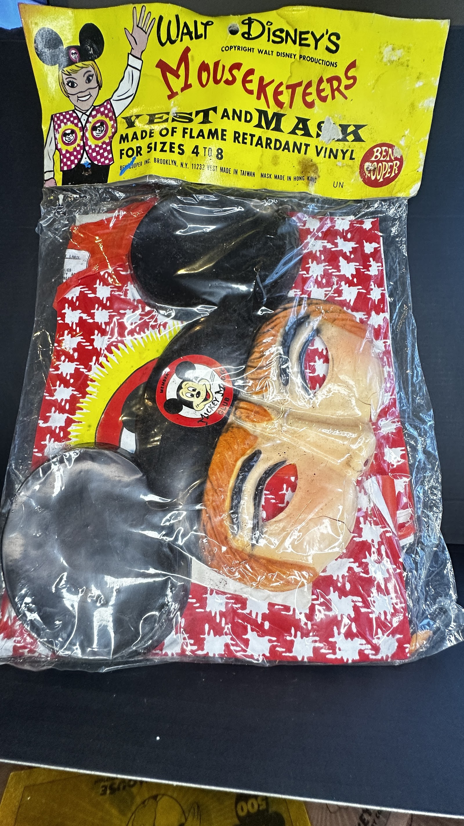 1970s Ben Cooper Mouseketeers Halloween costume set in original header-carded polybag, showing red and white houndstooth vinyl vest with yellow Mickey sunburst graphic and vacuum-formed plastic mask