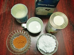 Cho sữa tươi, bột cacao, đường vào máy xay sinh tố xay vài vòng cho hỗn hợp hòa đều rồi để sang 1 bên. Lấy kem tươi cho vào tô và dùng máy đánh trứng đánh cho kem bông lên là được.