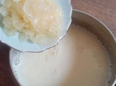 Khi nước rau câu sôi, cho phần nước nhãn đã xay vào rồi thêm 1 bịch sữa tươi, đun sôi lại sau đó cho tiếp phần nhãn cắt nhỏ, khuấy đều rồi tắt bếp.