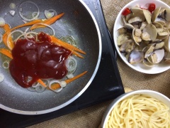 Vớt nghêu lên bỏ nước. Cho chảo nóng xào sơ cà rốt cắt sợi. Cho sốt cà chua ớt băm vào đảo nhanh tay. Cho mì vào đảo đều nhanh cho mì ngấm sốt thì cho ra dĩa.