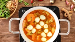 Nấu nước lèo đến khi sôi lăn tăn thì nêm thêm gia vị gồm 1/2 muỗng canh muối, 1 muỗng canh đường, 1/2 muỗng canh hạt nêm, 1/2 muỗng canh bột nghệ. Dùng muỗng khuấy đều để các gia vị hòa quyện với nhau, tiếp tục nấu đến khi sôi thêm 1 lần nữa thì cho 10 quả trứng cút vào nấu thêm 2 phút.