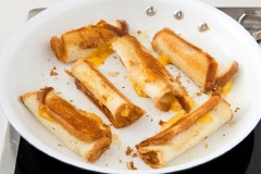 Chuẩn bị nguyên liệu. Sandwich bạn mua về cắt 4 góc viền rồi cán mỏng nhé. Đặt phô mai vào theo kích thước của bánh, bạn có thể cho thêm ít bơ muối vào rồi cuộn chặt lại. Bắc 1 chảo không dính lên bếp, cho sandwich lên nướng vàng.