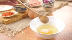 Làm nhân thịt băm cho bánh tráng mắm ruốc: Đun nóng 2 muỗng canh dầu ăn, phi thơm 2 muỗng canh tỏi băm rồi thêm 100gr thịt băm xào cho chín, nêm thêm 2gr tiêu vào cho thơm. Đập 1 quả trứng gà vào tô, mêm 1 muỗng cà phê bột nêm vào rồi đánh tan trứng.