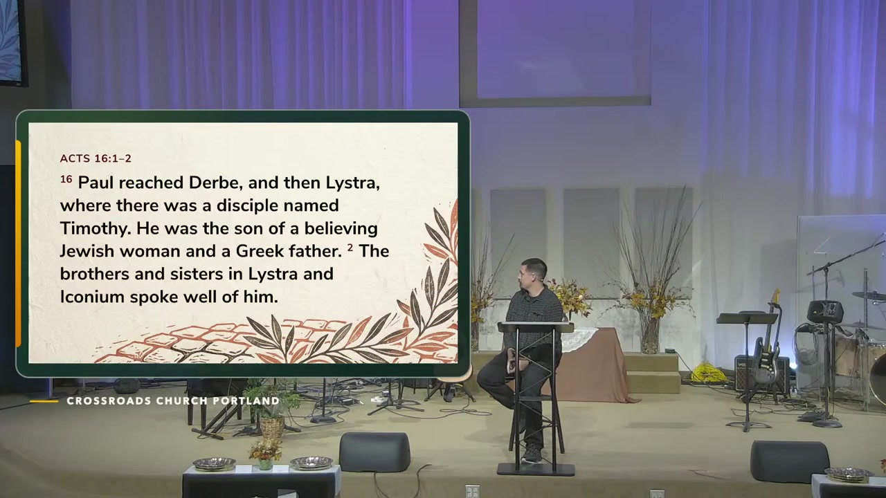 Christian teaching during Crossroads’ October 4 service beside the Acts 16:1–2 Scripture slide.