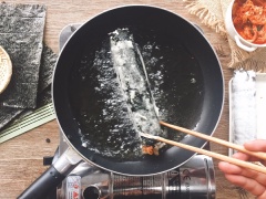 Khuấy bột chiên giòn với nướng lỏng vừa phải, sau đó lăn cuộn cơm qua bột 1 lớp mỏng, và bắt đầu chiên (dầu ăn bỏ vừa, không cần quá nhiều). Sau khi lớp ngoài hơi vàng, thì vớt cơm cuộn ra cho thấm qua 1 lớp khăn giấy. Cuối cùng cắt và thưởng thức với tương ớt.