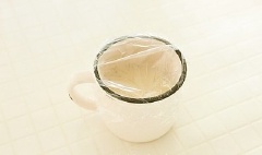 Tiếp theo cho hỗn hợp bột vào một chiếc cốc, lấy màng nylon bọc kín miệng lại.