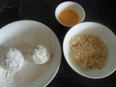 Tách lấy một lòng đỏ trứng gà đánh đều trứng. Lần lượt lăn các viên thịt bọc trứng qua bột mì, trứng gà rồi cuối cùng là bột chiên xù.