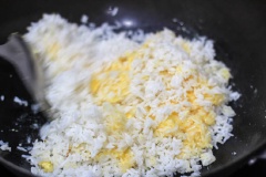 Đun nóng dầu ăn trong chảo ở lửa vừa, cho tỏi băm, gừng băm vào phi thơm, giảm lửa, cho 2 muỗng canh dầu ăn còn lại vào, cho hành lá băm vào, tắt bếp rồi đảo đều. Vớt hành, tỏi, gừng ra ngoài rồi cho cơm vào chiên trong khoảng 3 phút. Đánh tan trứng gà rồi cho vào cơm.