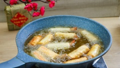 Bắc chảo dầu lên bếp, đợi dầu nóng cho từng cuộn chả giò vào chiên. Lật đều tay cho chả được chín đều và vàng thì vớt ra để ráo dầu.