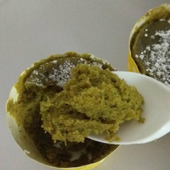 Thả chocochip vào giữa ly, ấn xuống một chút để tạo lõm. Để cupcake được mềm và hơi ướt ở giữa, đổ 1/2 thìa canh nước vào lõm (lên trên chocochip). Cho cupcake vào lò vi sóng, bật chế độ cao (HIGH) trong 75 giây để bánh còn ẩm nước. 90 giây thì bánh sẽ mềm và hơi khô. Trong hình là bánh sau 80 giây. Lấy bánh ra, thêm kem phủ hoặc rây chút đường bột để trang trí. Thưởng thức ngay khi còn nóng.