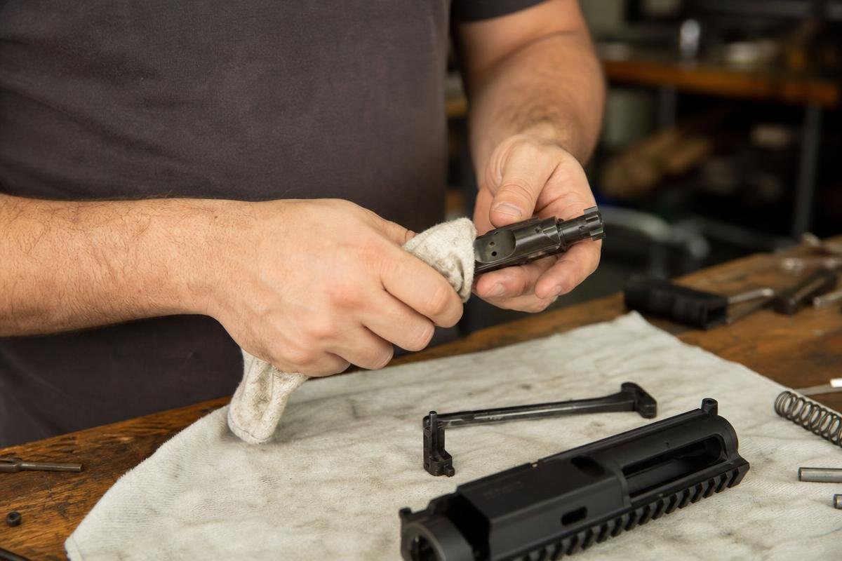 Excess lubricant being wiped from an AR-15 bolt carrier group