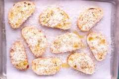 Kế tiếp bạn bào phô mai parmesan lên mặt bánh, rắc tiêu lên, có thể rắc muối và các loại rau mùi nếu bạn thích nhé. Cho khay vào lò nướng trong 5 phút cho đến khi bánh vàng đều là được.