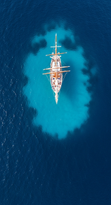 Overhead Aerial of a Classic Schooner Sailboat in Deep Blue Turquoise Ocean Water