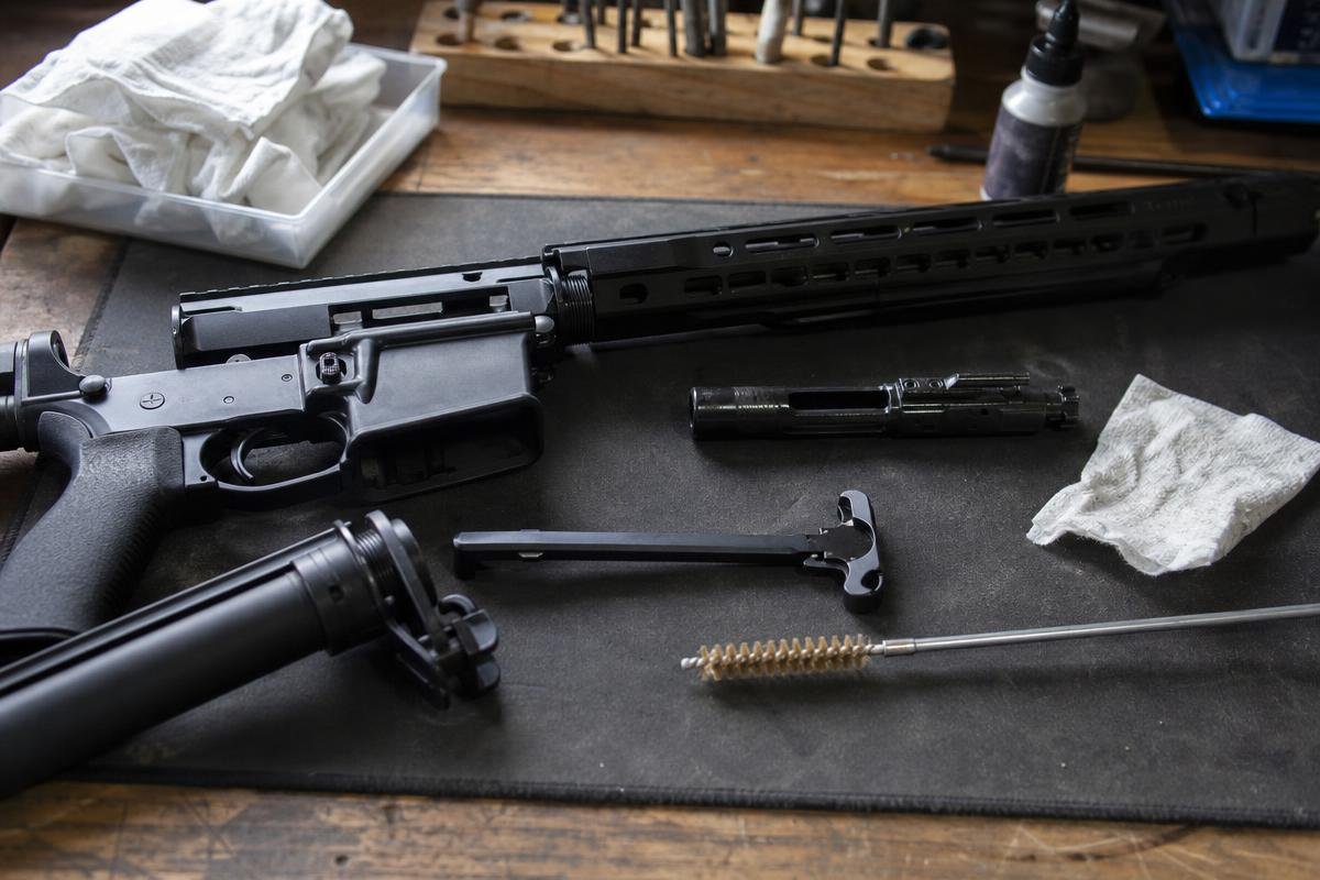 AR-15 bolt carrier group cleaning tools and components on a workbench