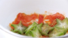 Làm nóng 3 muỗng canh dầu ăn trong chảo, cho cá vào chiên sơ 2 mặt rồi tắt bếp. Trên một chiếc nồi khác, làm nóng 2 muỗng canh dầu ăn rồi cho 1/3 số cà chua cắt múi cau vào xào cho nhừ. Tiếp theo cho khế cắt lát, nước ép khế vào xào sơ.