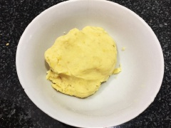 Trộn vào mỗi bát khoai 100gr bột nếp và 200gr đường, nhào bột thật đều cho bột mịn, tạo thành 1 khối như hình là được.