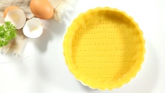 Dùng nĩa xiên vào đáy khuôn bột những lỗ nhỏ. Lót lên trên một tấm giấy nến rồi đổ đậu vào lòng khuôn, đem đế tart đi nướng lần 1 10 phút ở 200 độ C. Việc cho đậu vào giữa khuôn sẽ giúp đế tart không bị nở phồng trong lúc nướng. Sau khi nướng 10 phút thì lấy bỏ phần đậu ra ngoài, tiếp tục nướng bánh trong lò thêm 10 phút nữa.