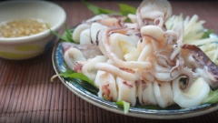 Trong chén nhỏ, trộn đều nước mắm, nước cốt chanh, đường và tỏi băm. Xếp rau dăm và gừng vào đĩa. Mực vừa chín tới thái khoanh tròn bày lên trên, ăn nóng cùng nước mắm hoặc muối tiêu chanh nếu thích..