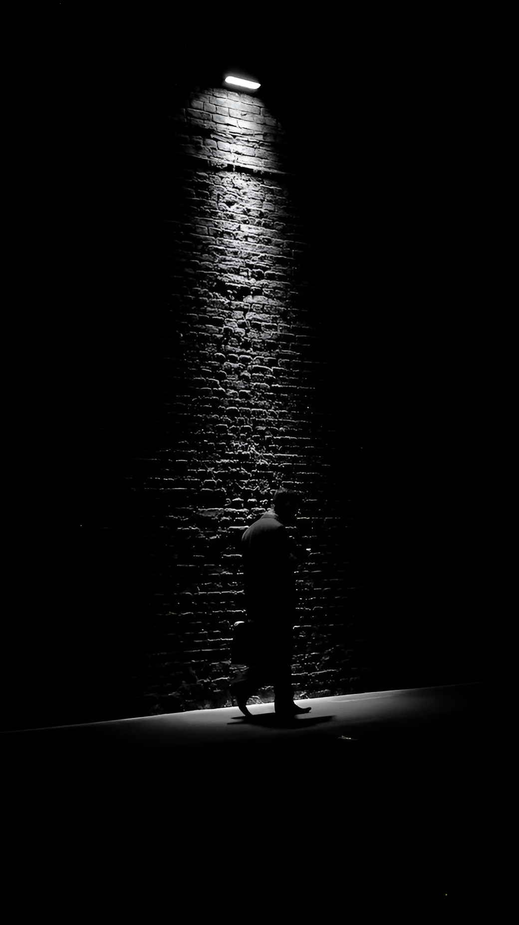 Monochrome Silhouette Against Brick Wall Spotlight - Free 4K mobile Wallpaper