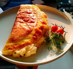 Nhấc nghiêng chảo cho trứng chiên nằm giữa đĩa, dùng sạn gấp trứng lại như hình. Thêm vài lát sandwich hoặc thưởng thức với cơm nóng kèm xà lách và cà chua. Yummy !!