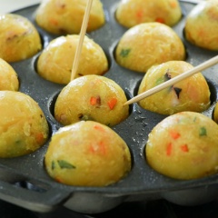 Bật lò nướng takoyaki lên, dùng giấy thấm dầu thoa dầu đều khắp khuôn. Đổ hỗn hợp bột lên cỡ nửa khuôn, nướng bánh bạch tuộc khoảng 3 phút. Sau 3 phút, lật bánh nghiêng một góc và đổ thêm bột, dùng que tre lật bánh nướng cho tròn đều. Nướng đến khi bánh chín và ngả màu vàng là được. Làm lần lượt cho đến khi hết hỗn hợp bột.
