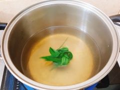 Cho vào khoai mì 100gr đường rồi trộn đều. Để khoảng 10 phút rồi vắt khoai thành từng viên tròn. Cho đường và khoảng 500ml nước vào nồi, nấu cho đường tan hết. Lá dứa rửa sạch rồi cuộn lại thành bó cho vào nồi. Nước sôi thì cho khoai mì vào nấu.