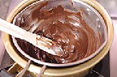 Đem 2 loại chocolate đen và trắng trộn với nhau, bẻ vụn và cho vào nồi, đun chảy.