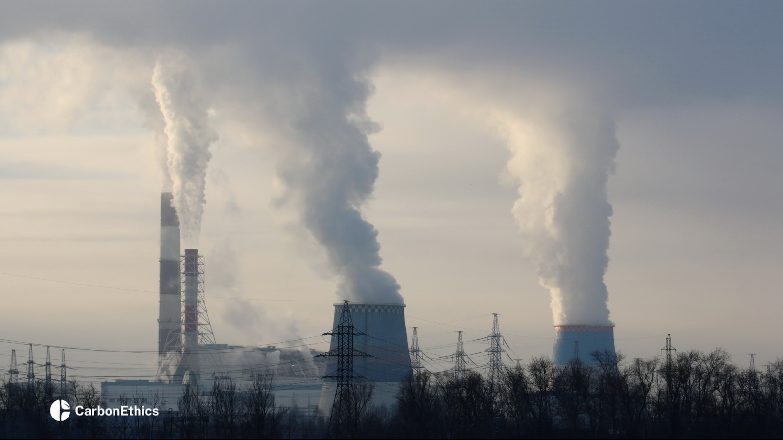 A gloomy, gray-toned image of industrial smoke billowing from a factory and merging into the clouds.