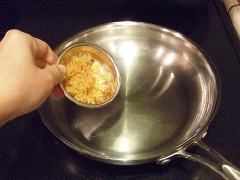 Cho 3 muỗng canh dầu ăn vào chảo, đun nóng. Cho 2 muỗng cà phê tỏi vào phi thơm. 