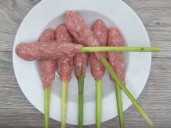 Chị em tiến hành nặn chả bằng cách xúc 1 thìa thịt lên cho vào lòng bàn tay rồi dàn mỏng, sau đó đặt 1 cây sả vào giữa, gói thịt lại cho chặt tay đến khi thịt bám vào quanh cây sả là được, cứ như thế làm đến hết ( lưu ý không nên nặn chả quá to sẽ khó chín khi chiên)