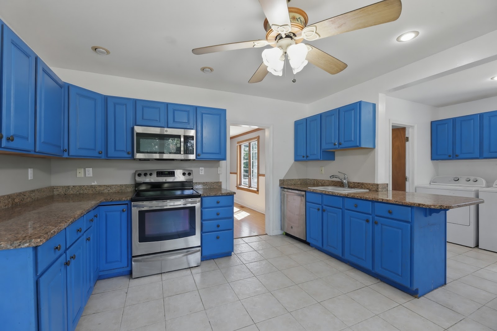 Outdated kitchen with bold blue painted cabinets and older tile floors — a South Jersey home with strong potential for a full kitchen remodel