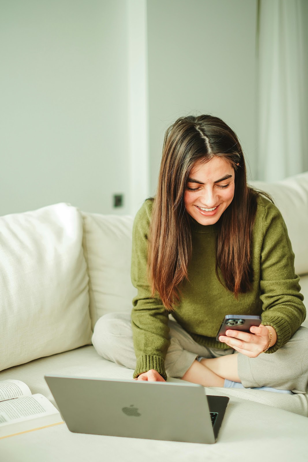 Confident woman texting with success stories floating around her