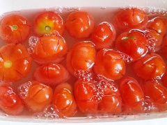 Hòa nước vôi, lọc lấy nước trong, ấn dẹt cà chua cho bớt hạt rồi ngâm vào nước vôi trong từ 6 đến 8 tiếng (có thể ngâm qua đêm). Bước này giúp cà chua khi sên mứt không bị nát.