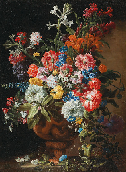 Carnations lillies nigellas and other flowers in a decorative terracotta vase on