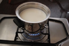 Làm kem sữa tươi: Cho 250ml sữa tươi, 1 muỗng cà phê tinh chất vani vào nồi. Đặt nồi sữa và vani lên bếp đun lửa nhỏ cho ấm thì tắt bếp.