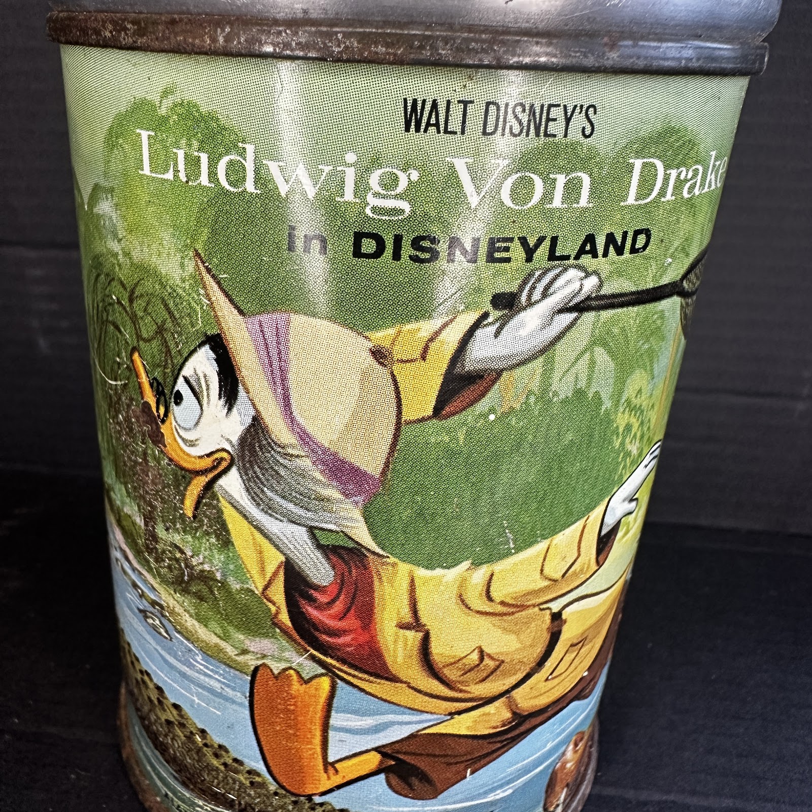 Vintage lithographed tin wastebasket circa 1961–1963 featuring Ludwig Von Drake in safari gear with butterfly net against a green forest and blue water background, with Walt Disney's Ludwig Von Drake in Disneyland branding
