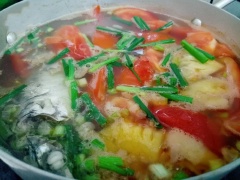 Khi nồi canh bắt đầu sôi thì cho cá vào. Khi canh sôi lên lần nữa thì cho thơm vào. Canh sôi lên lần nữa thì nêm nếm lại gia vị cho vừa ăn rồi cho hành lá và tiêu vào rồi tắt bếp.
