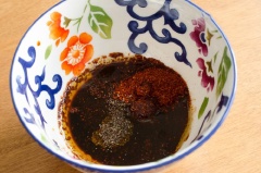 Chuẩn bị sốt dầu ớt: cho 4 muỗng cà phê ớt bột Hàn Quốc, 1.5 muỗng canh nước tương, 1 muỗng canh đường, 1 muỗng canh dầu mè, 1/4 muỗng cà phê bột tỏi, 1/4 muỗng cà phê tiêu, khuấy đều để đường tan và hỗn hợp hòa quyện vào nhau.
