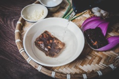 Trong lúc đợi cá chín, chúng ta sẽ chuẩn bị nước sốt me. Cho 100 gram me vào một cái chén, đổ nước sôi vào và dùng muỗng dầm. Lọc lấy phần nước cốt me, bỏ phần hạt.