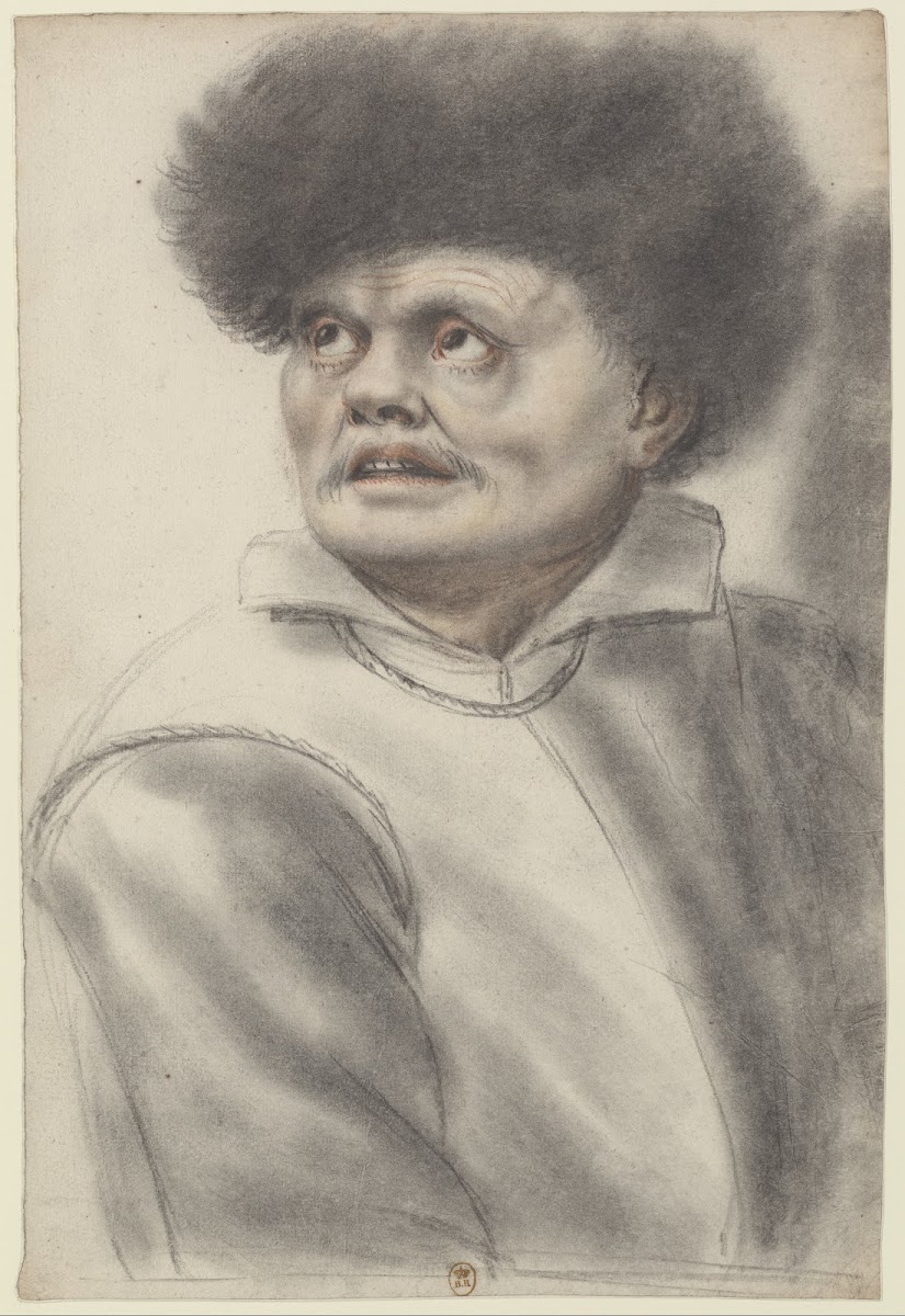 Homme coiffé dun bonnet de fourrure les yeux levés vers le ciel vu de trois quar
