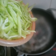 Lột bỏ vỏ hành tím, cắt mỏng. Bật bếp, đặt chảo lên bếp, cho vào chảo 1 muỗng canh dầu ăn. Cho hành tím vào phi thơm, hành đã dậy mùi thơm thì tiếp tục cho khổ qua đã ráo nước vào xào nhang tay trên lửa lớn để khổ qua giòn, xanh và không bị nhũn.