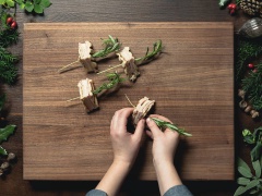 Bạn xếp bánh mì lên bếp nướng, nướng chín vàng 2 mặt. Cho bánh mì ra thớt rồi cắt làm 4. Khéo léo dùng nhánh lá hương thảo xiên qua bánh mì nhằm cố định bánh không bị bung rớt.