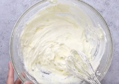 480g kem phô mai cho vào âu lớn cùng 135g đường và dùng máy đánh trứng đánh cho bông đều. 250g heavy cream để cho lạnh rồi lấy ra cho vào âu khác, dùng máy đánh bông lên. Sau đó trộn heavy cream vừa đánh với hỗn hợp kem phô mai đến khi thành hỗn hợp mịn mượt. Tiếp theo cho xoài xắt nhỏ vào trộn đều lên. Đổ hỗn hợp kem này vào khuôn bánh đã lót lớp bánh lady finger, dàn đều ra và đặt vào ngăn mát tủ lạnh.