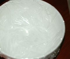 Ngâm gelatine vào nước lạnh 15 phút cho nở. Pha kem tươi với sữa tươi và đường, nếm cho độ ngọt phù hợp với khẩu vị của bạn. Sau đó khuấy đều đun nóng nhưng không sôi, thêm gelatin vào khuấy tan hoàn toàn, cuối cùng thêm tinh dầu hạnh nhân rồi tắt bếp. Chống dính khuôn bằng cách lót một lớp màng bọc thực phẩm dưới đáy – ở đây mình dùng tô cho tiện. Đổ hỗn hợp trên vào và để trong tủ lạnh đến khi đông lại là xong phần khúc bạch.