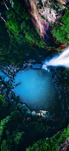 Aerial View of Jungle Waterfall Plunging into Blue Pool